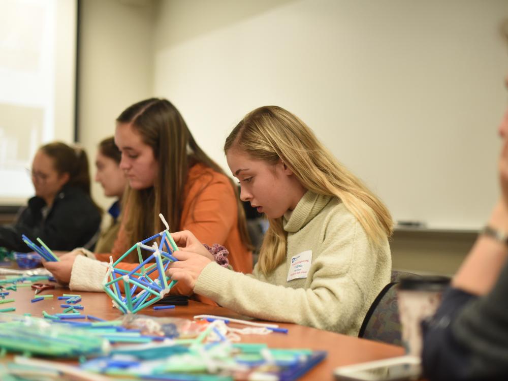 Victoria Purchase works to create a dome during Women in Engineering Day at Penn State Behrend.