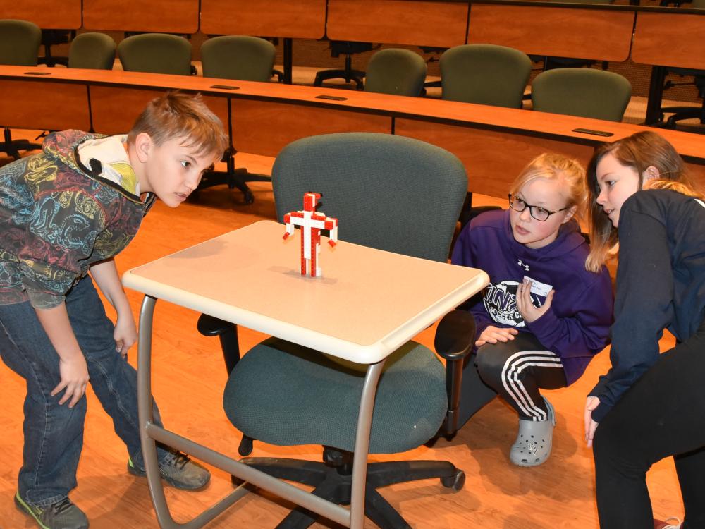 Beaty-Warren Middle School seventh-grade student Kole Howard, left, observes a LEGO robot during the “LEGO Person” activity at 21st Century Kids, held Friday, April 20, at Penn State Behrend. 