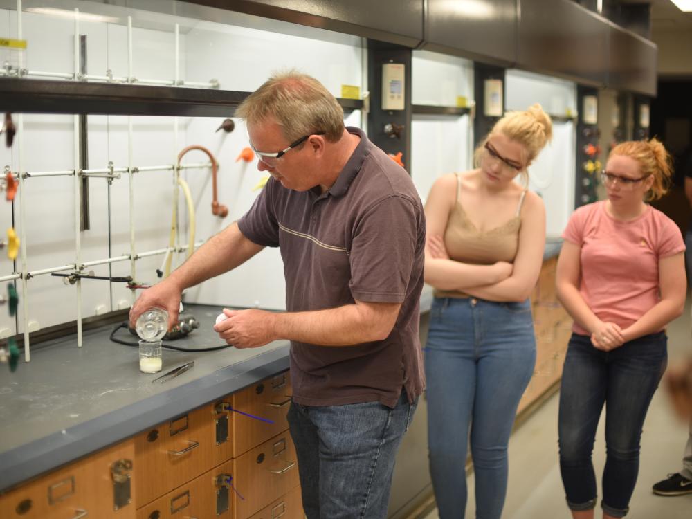 Jerry Magraw, a senior technician, instructs McDowell High School students on creating a compound containing an ester during a chemistry outreach event held Wednesday, May 17, at Penn State Behrend.