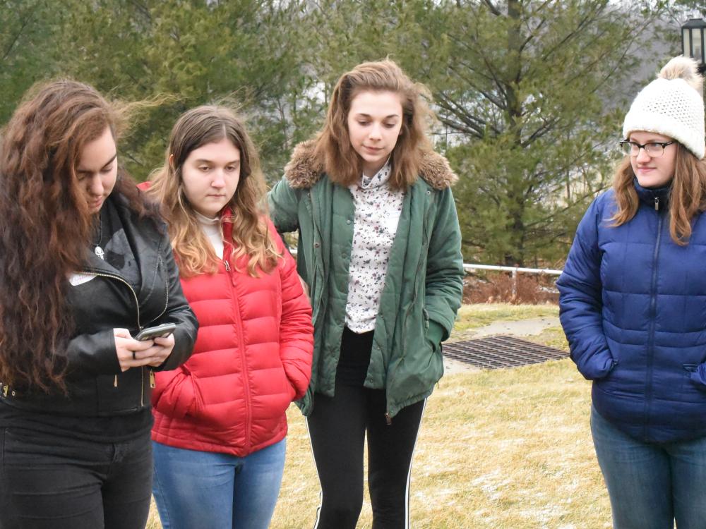 Tori Schwartz, left, collects a GPS point while Claire Dodds and classmates look on. 