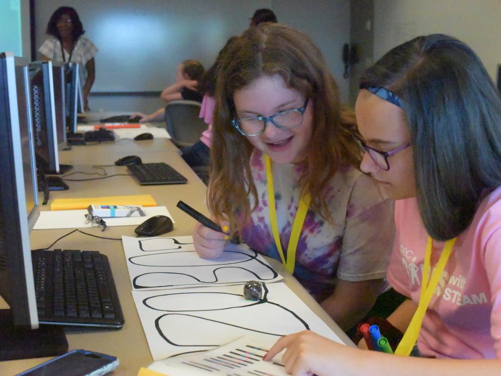 Emma Stafford, left, and Kendra Kope, both students in the General McLane School District, program an Ozobot during the Wabtec Girls With Steam program.