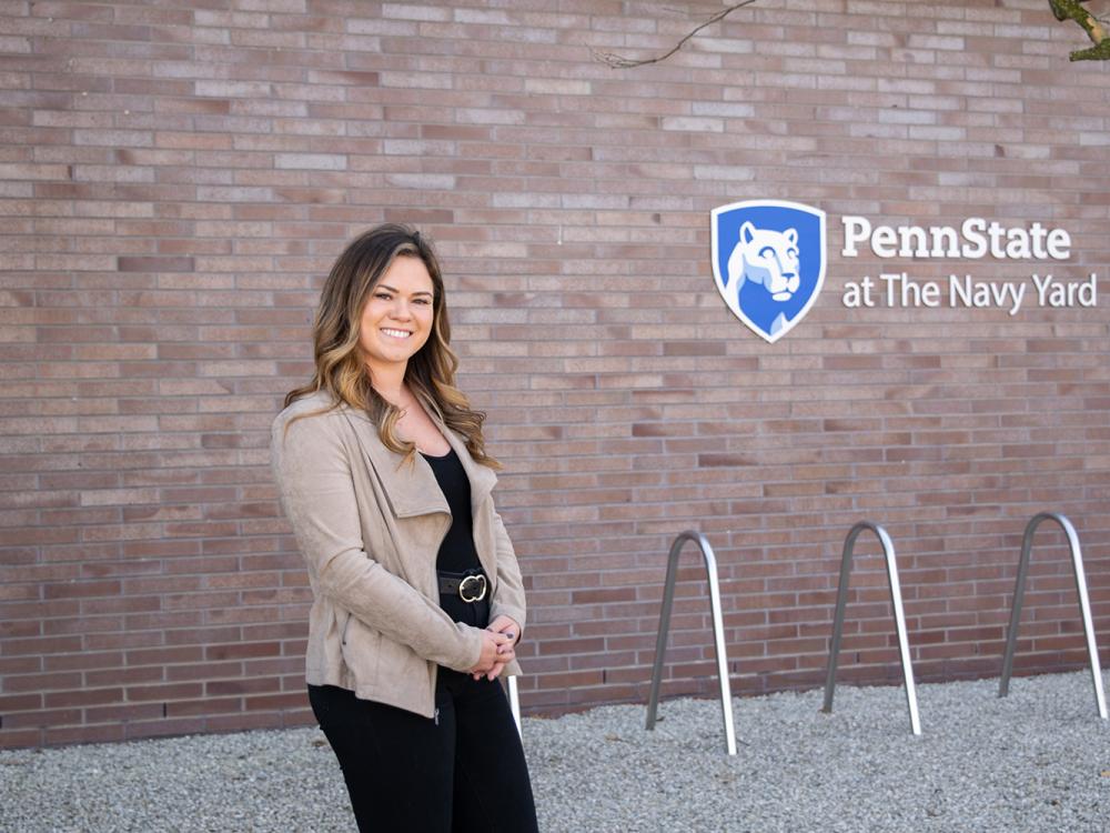 Alexis Doherty standing in front of a wall with the Penn State at the Navy Yard logo