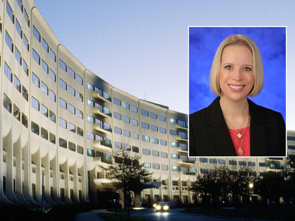 A head and shoulders professional photo of Dr. Jennifer Kraschnewski against a picture of Penn State College of Medicine. 