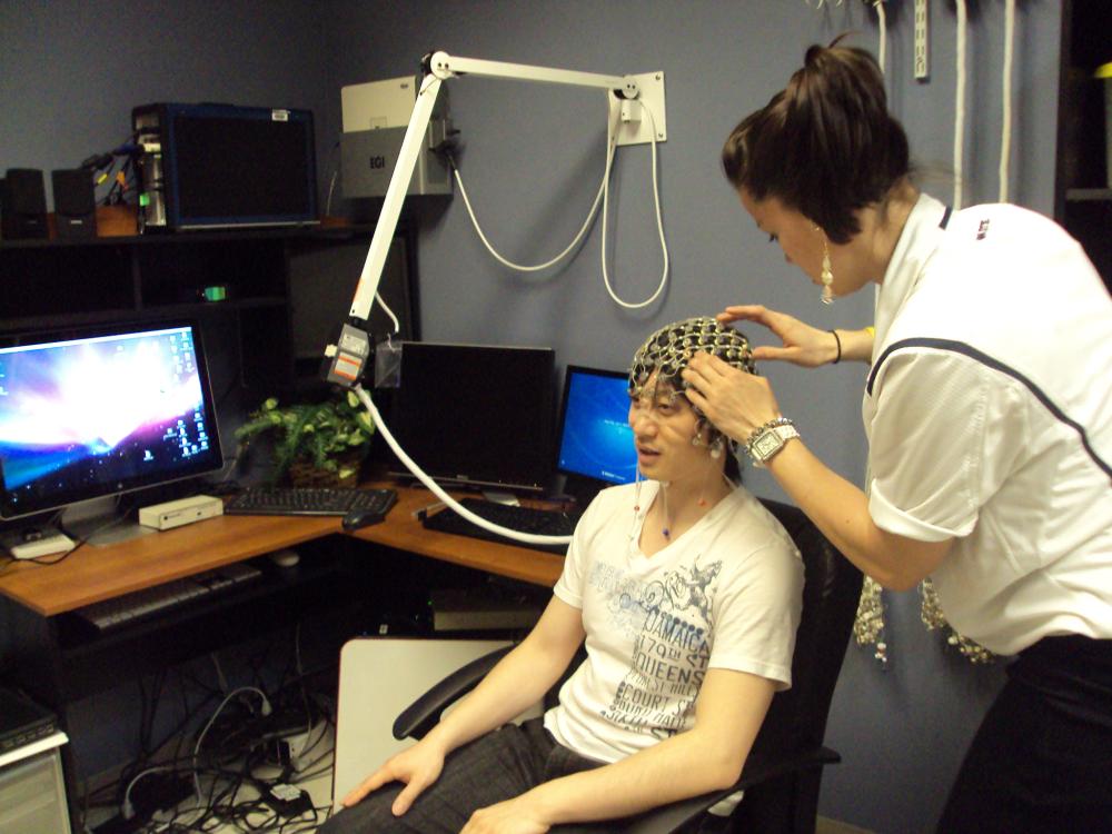 woman fitting man with EEG cap
