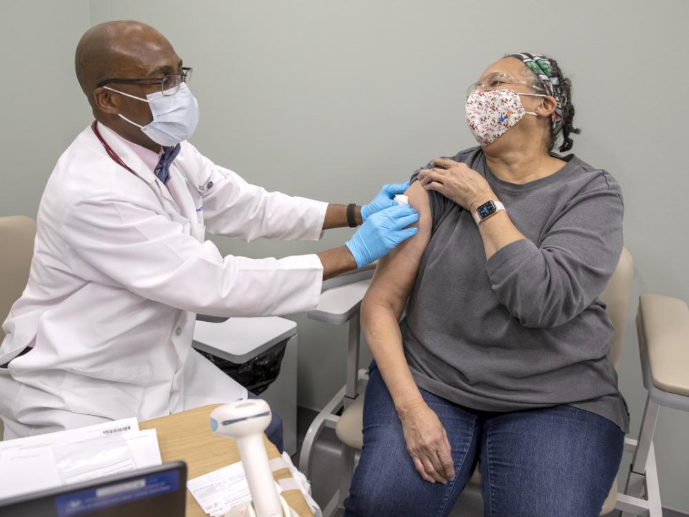 Dr. Stephen Henderson of Penn State Health Cocoa Outpatient Center shares a laugh with 71-year-old Cornelia Brown of Chambersburg after giving her the first dose of the COVID-19 vaccine.