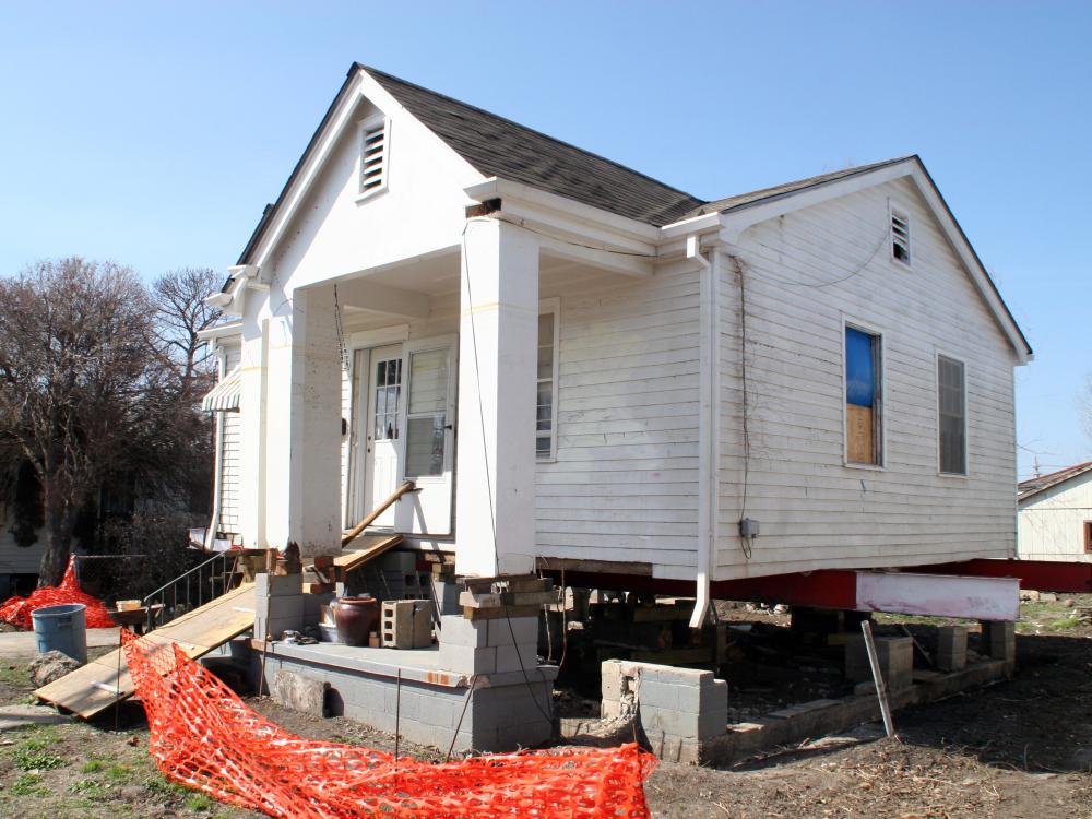 Large house being raised above the ground to protect from flooding