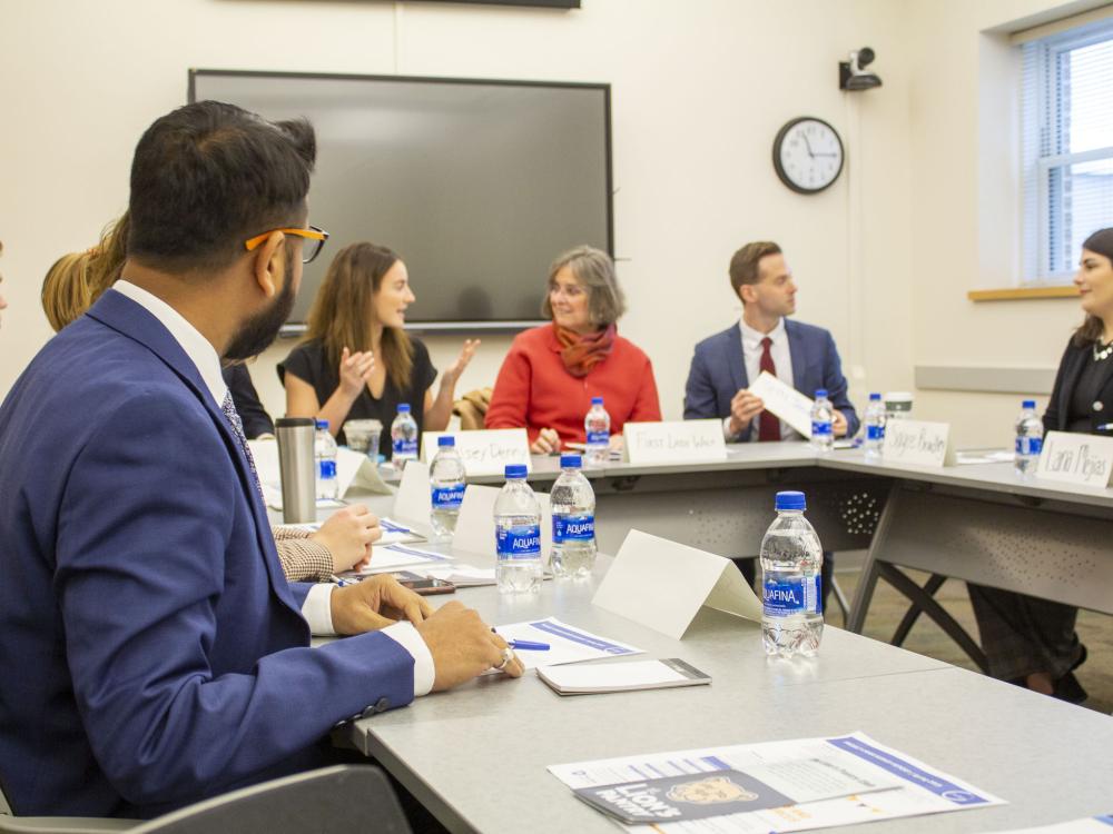 First Lady Wolf sits with students around a table