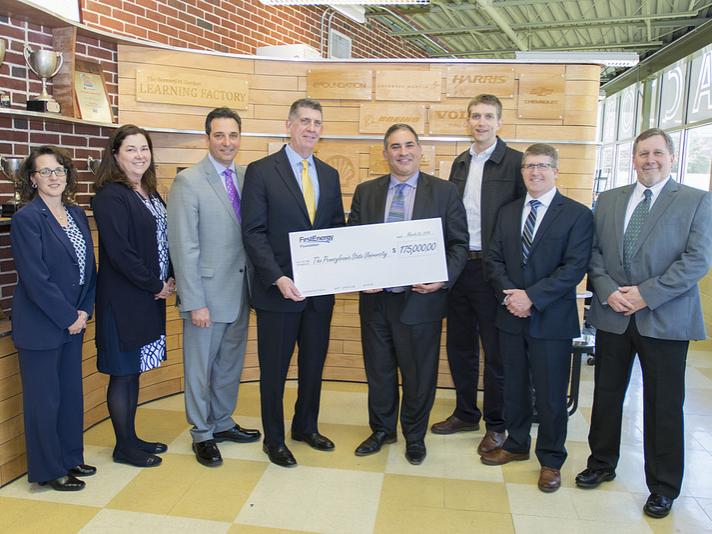 FirstEnergy and Penn State representatives holding a large check