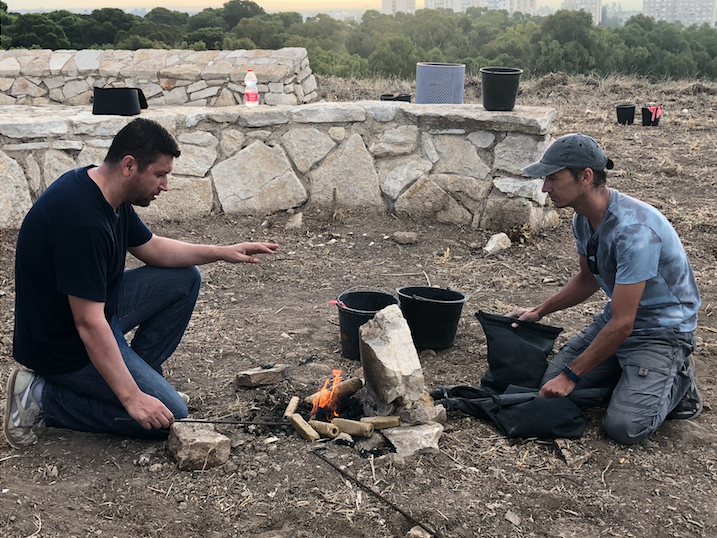 two men operate a recreated hearth