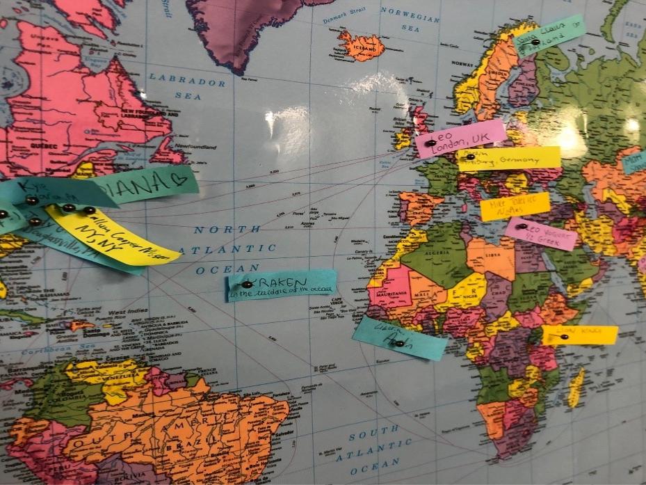 A photo of a world map with pins depicting the home countries of the students in the GEC