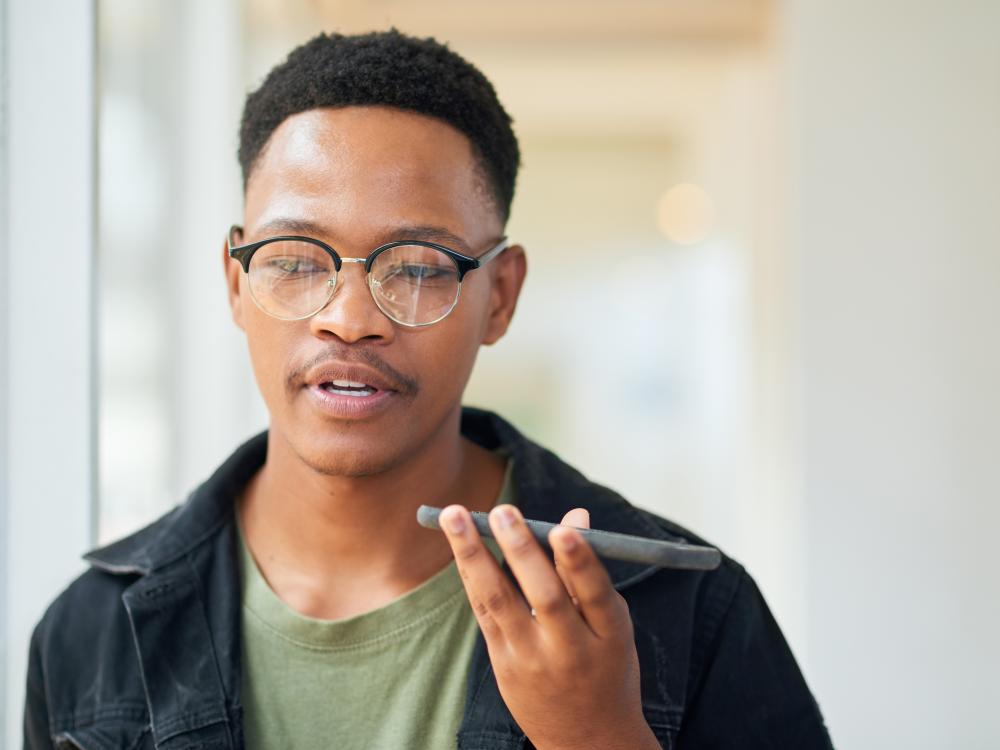 Man speaking into a cellphone in his hand as he walks