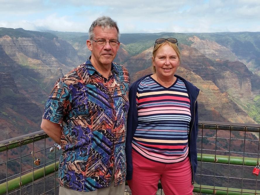 Joan and Ken Miller pose for a photo in front of an overlook in Hawaii