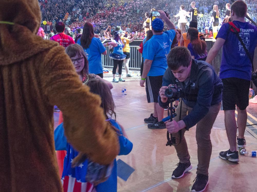 Penn State student Ryan Heidig films families and the Penn State mascot during the 2016 THON event at BJC.