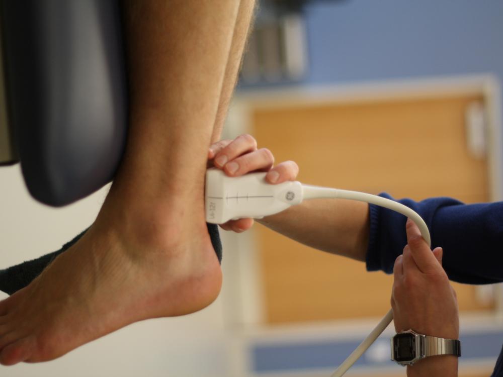 Neuromuscular electrical stimulation being applied to a Achilles tendon injury. 