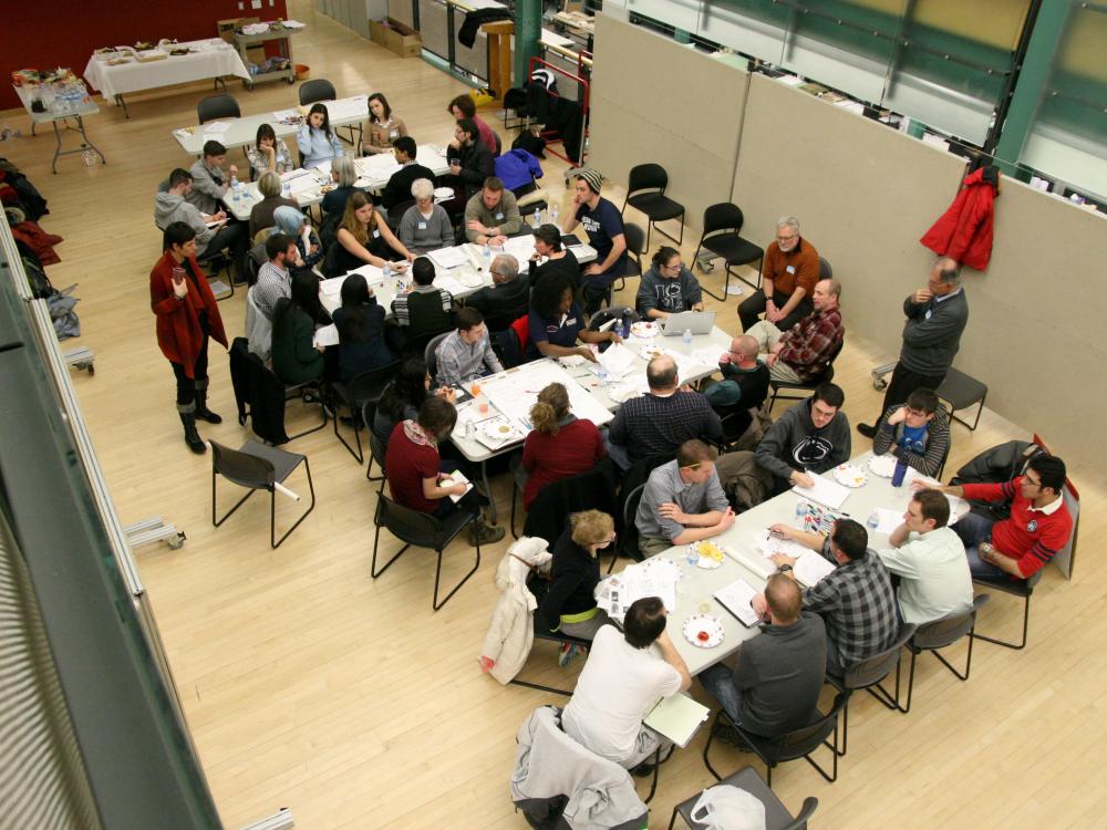 Overhead view of group of people working around tables