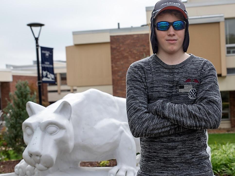 Mackinly Adams stands by lion statue