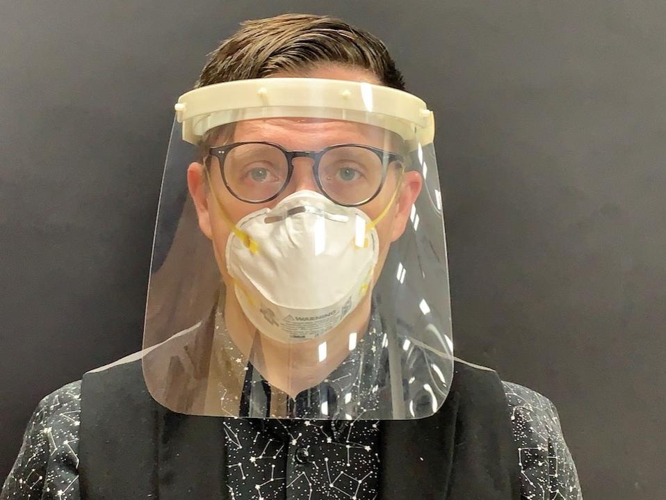 A man models a plastic medical face shield