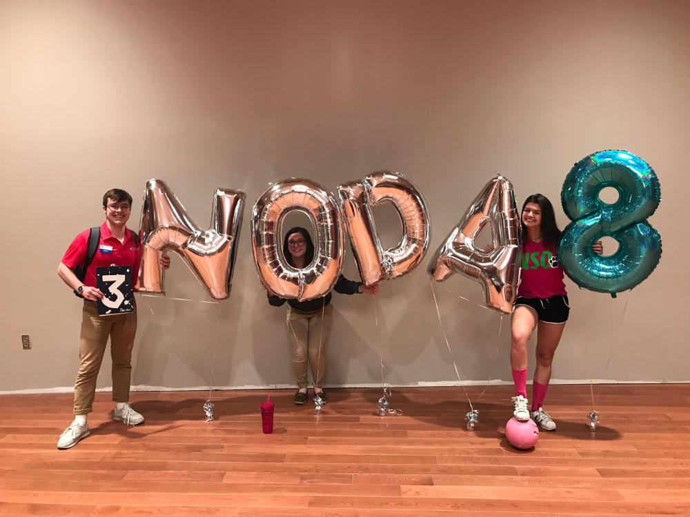 Students pose with balloons that read NODA 8