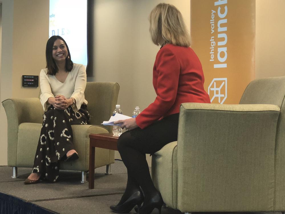 Two women on a stage interviewing