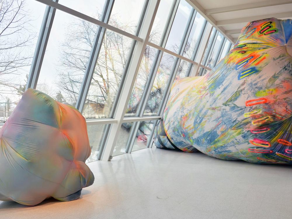 Large, colorful inflatable rocks in a gallery