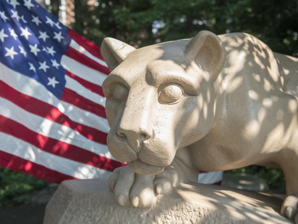 Lion shrine with an American flag waving behind it