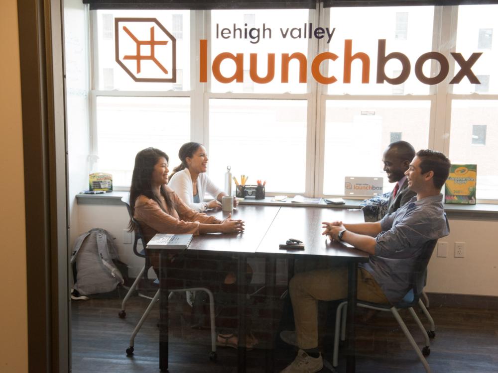 A group of students sit in co-working space of LaunchBox.