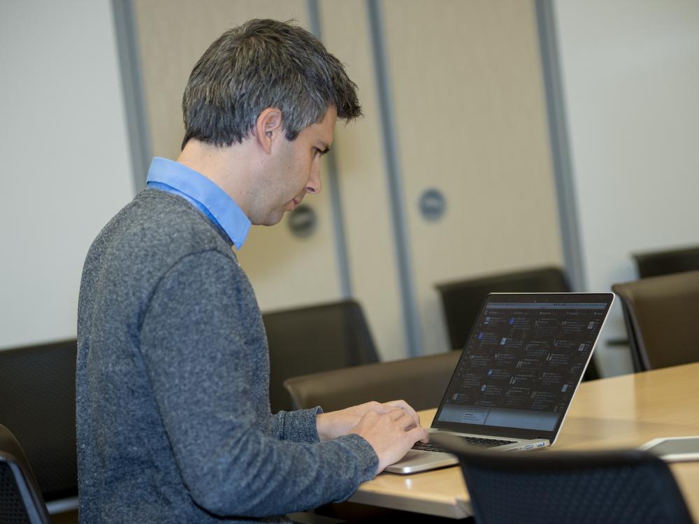 Marcel Salathé sits in front of his laptop while studying social media site