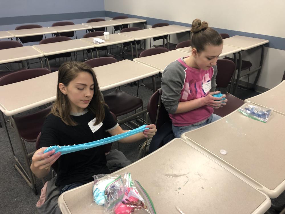 Danica Park, left, and Kristine Wurst play with the slime they created during "The Science of Slime" workshop at Penn State Behrend's Math Options Career Day.