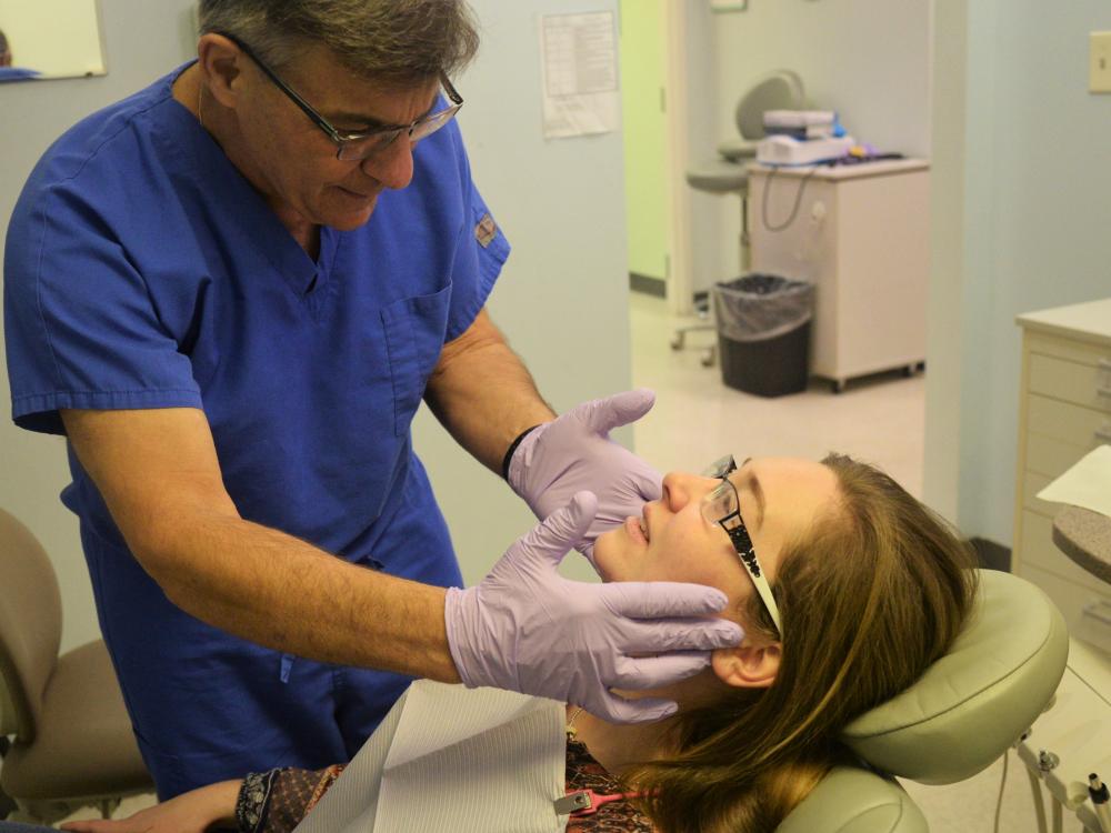 Dr. Barry Stein, a local dentist who volunteers with the Centre Volunteers in Medicine, preforms a checkup on Jane Pennington at the CVIM dental clinic.