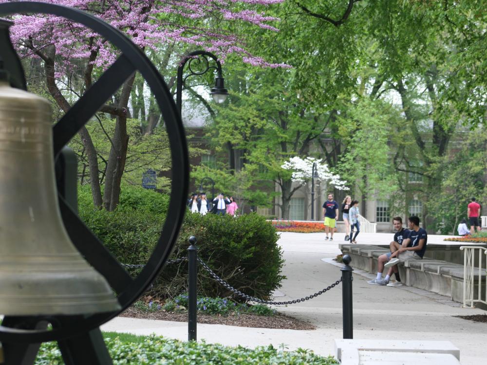 Students mingle around Old Main on the University Park campus