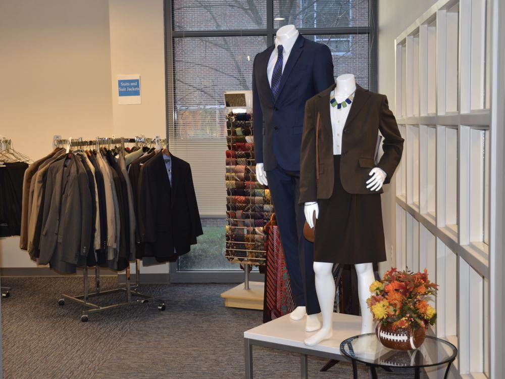 clothing rack with suit jackets and models wearing suits