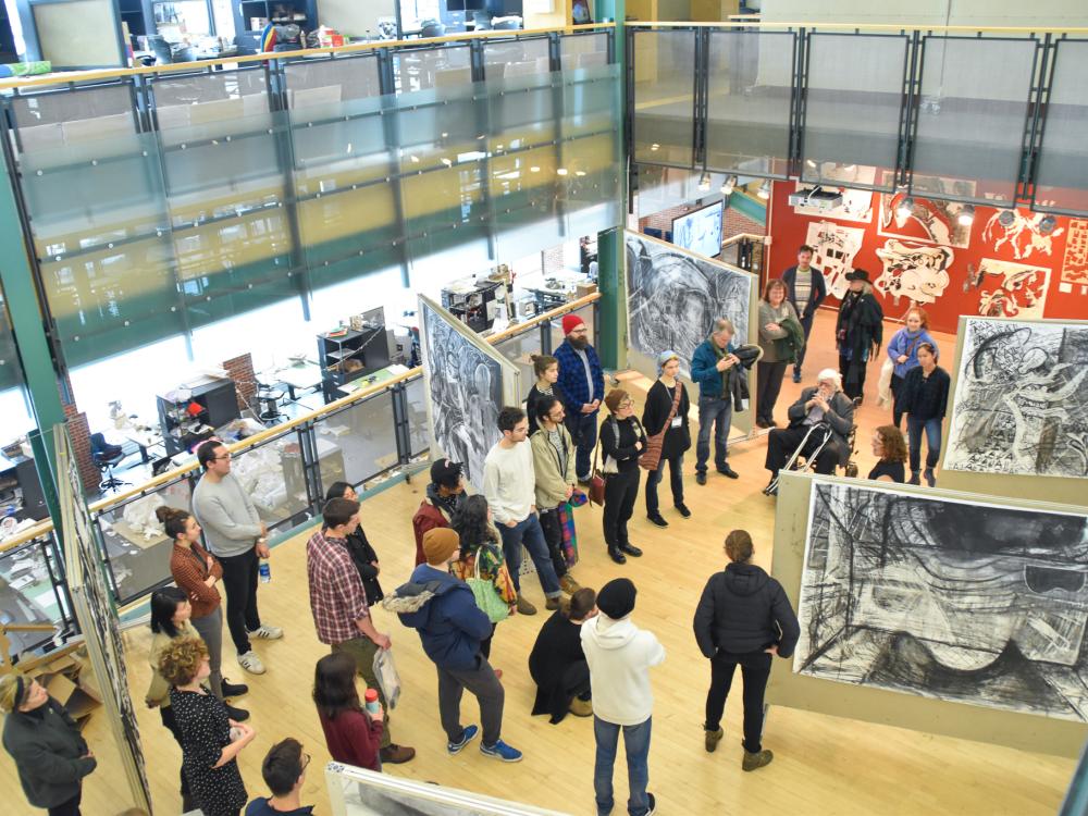 Braasch surrounded by participants in the Robert Reed Drawing Workshops at Penn State during an exhibition of work done.