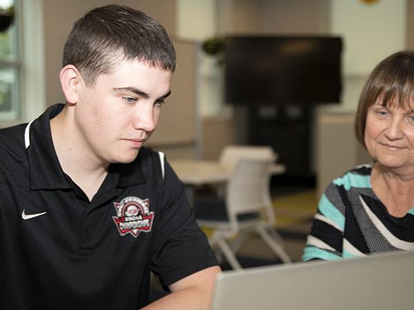 As a SAGE den parent, Rita Gumbert (right) checks in with Eric Silbaugh (left) regularly.