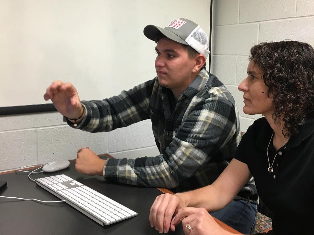 Wyatt Ritchie shows work on computer to Marietta Scanlon