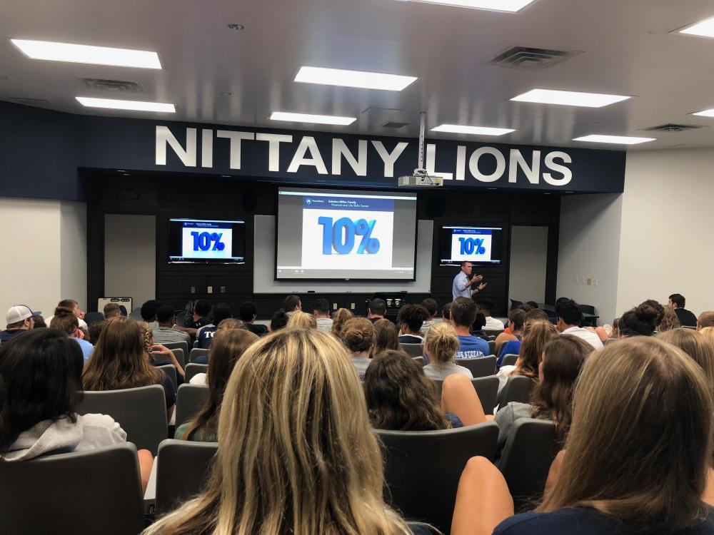 Student athletes watch a financial literacy presentation