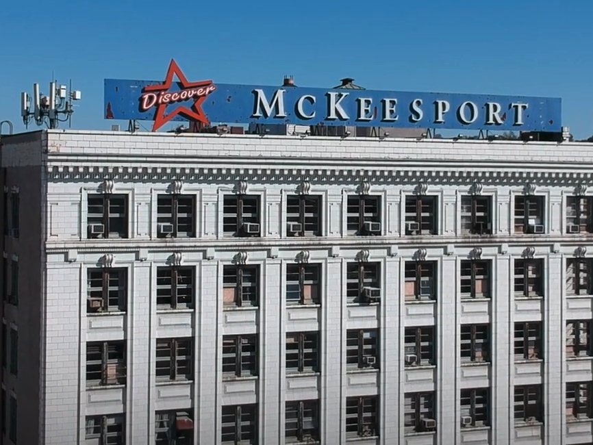 Building with a sign on the roof that reads Mckessport. 