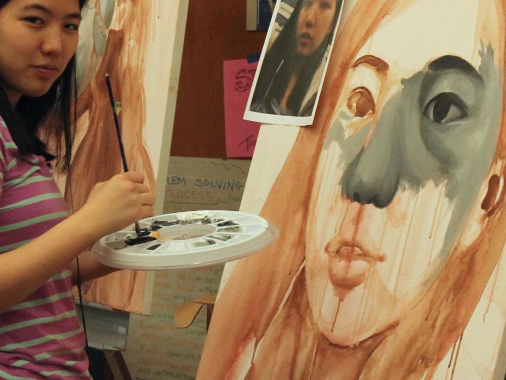 student paints a self-portrait