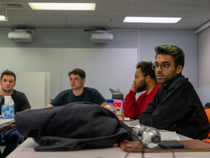 Four students meet in a classroom