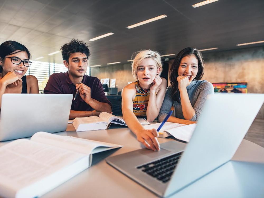 four students looking at computer