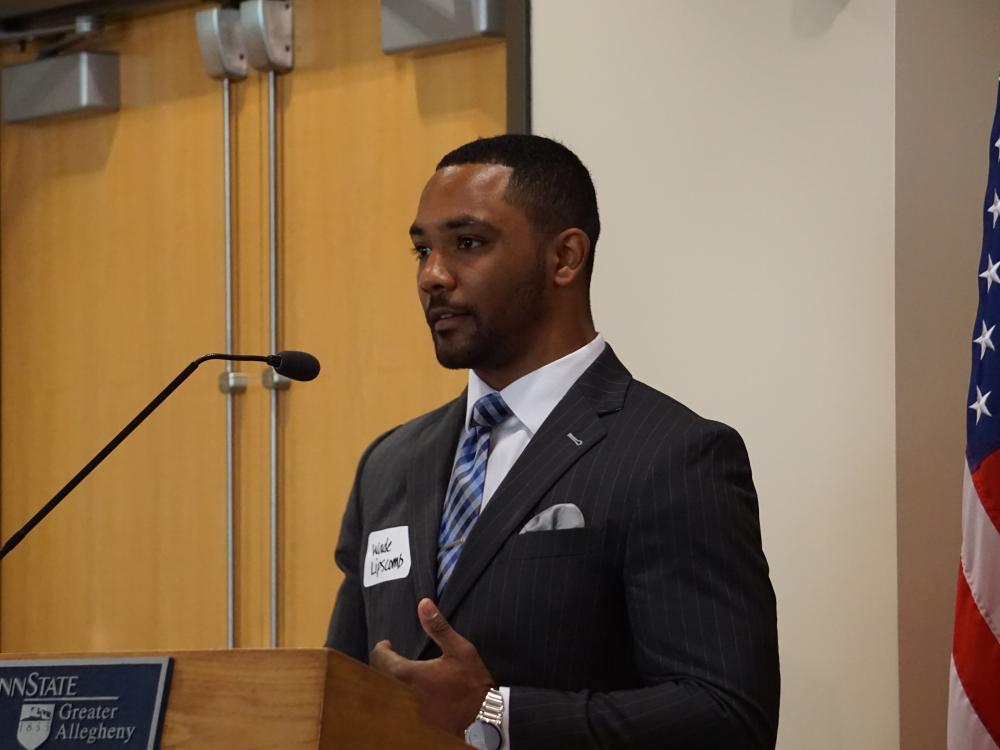 Man standing at podium talking into a microphone