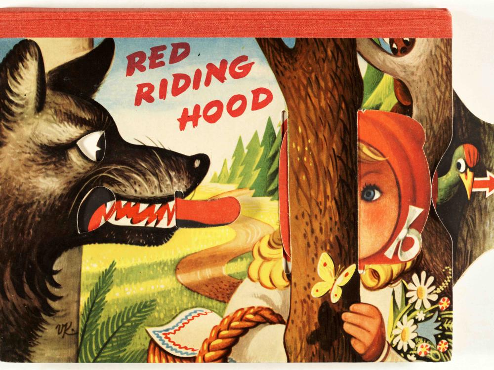 scanned color cover of children's movable book showing big bad wolf with movable tongue and girl wearing red hiding behind tree