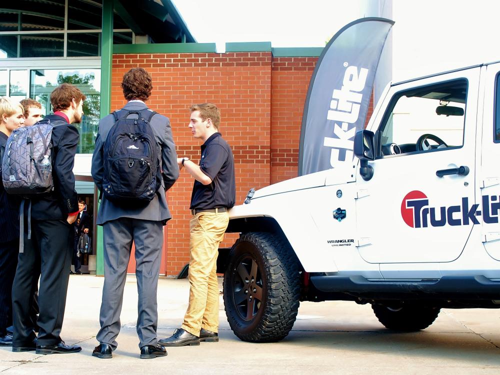 A corporate recruiter talks with several students at a Penn State Behrend career fair.