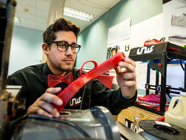 Nicholas Unis inspects a piece of his 3D-printed custom sneaker.