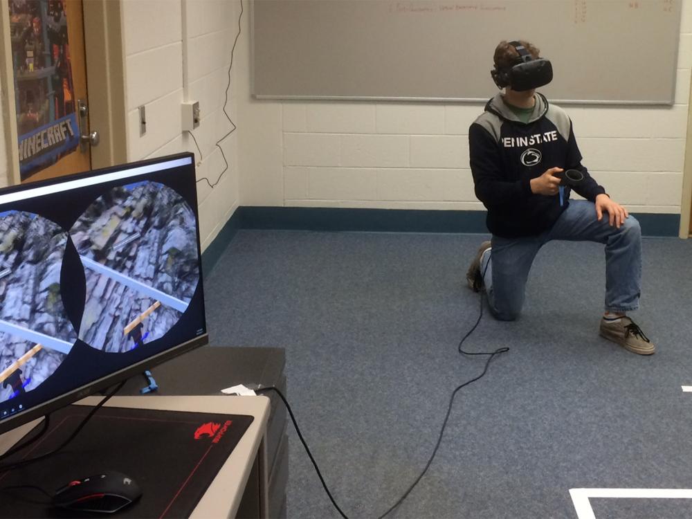 A student uses HTC Vive to measure the thickness of rock layers. The virtual content is synchronized to a desktop screen. 