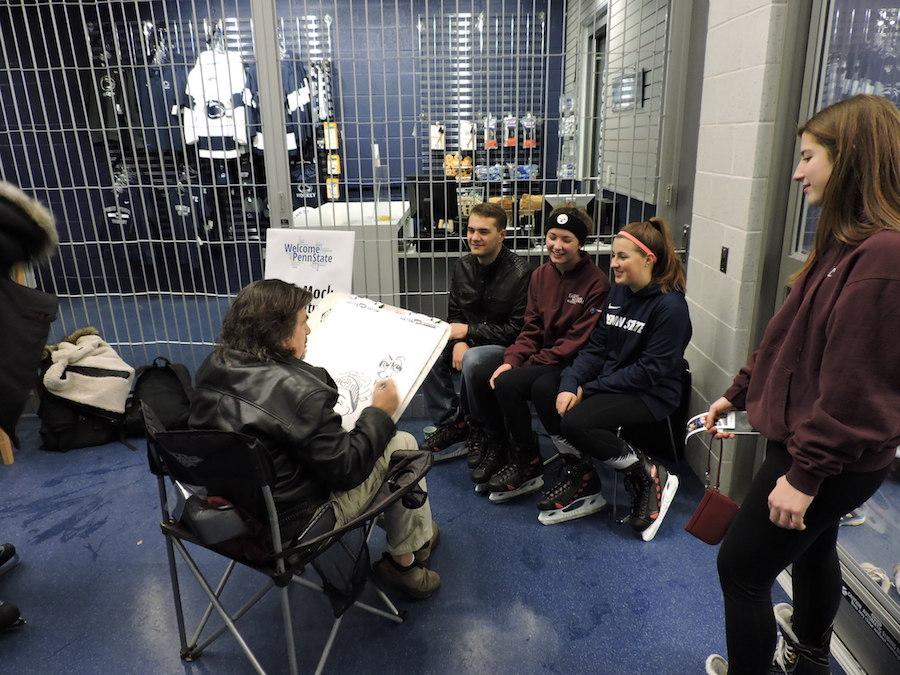 Students pose as they are sketched by a caricature artist during Welcome Week 2018