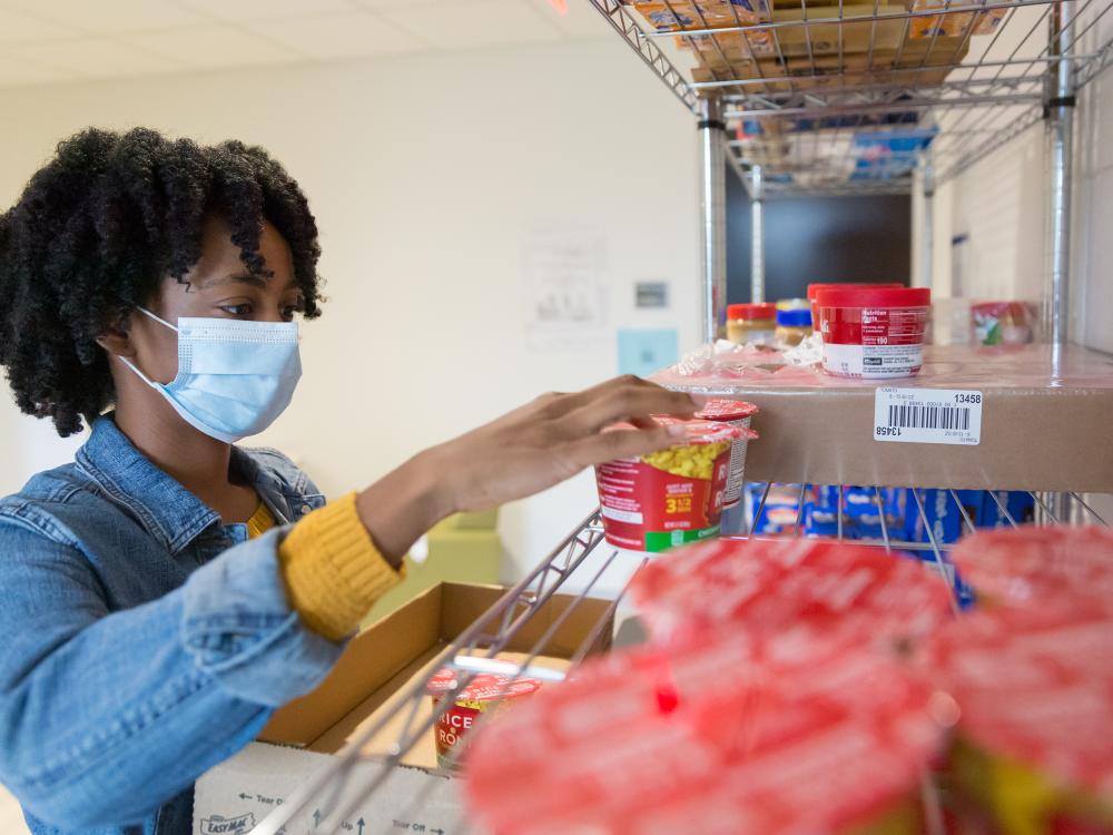 Brandywine student Angel Asomugha stocking the campus food pantry. 