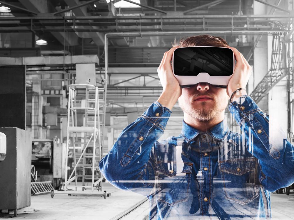 A man in a warehouse looks through a virtual reality headset.