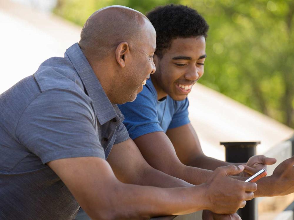 father and son talking and holding their mobile phones