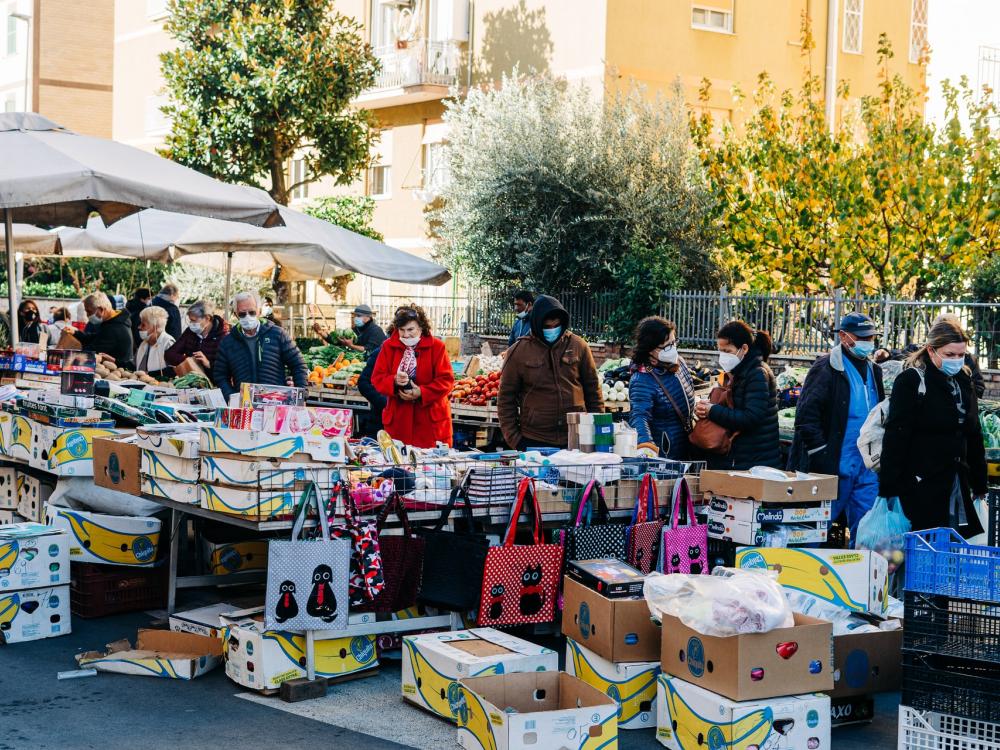 People wearing face masks shop at outdoor market