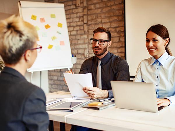 Stock photo of two young professionals interviewing a third